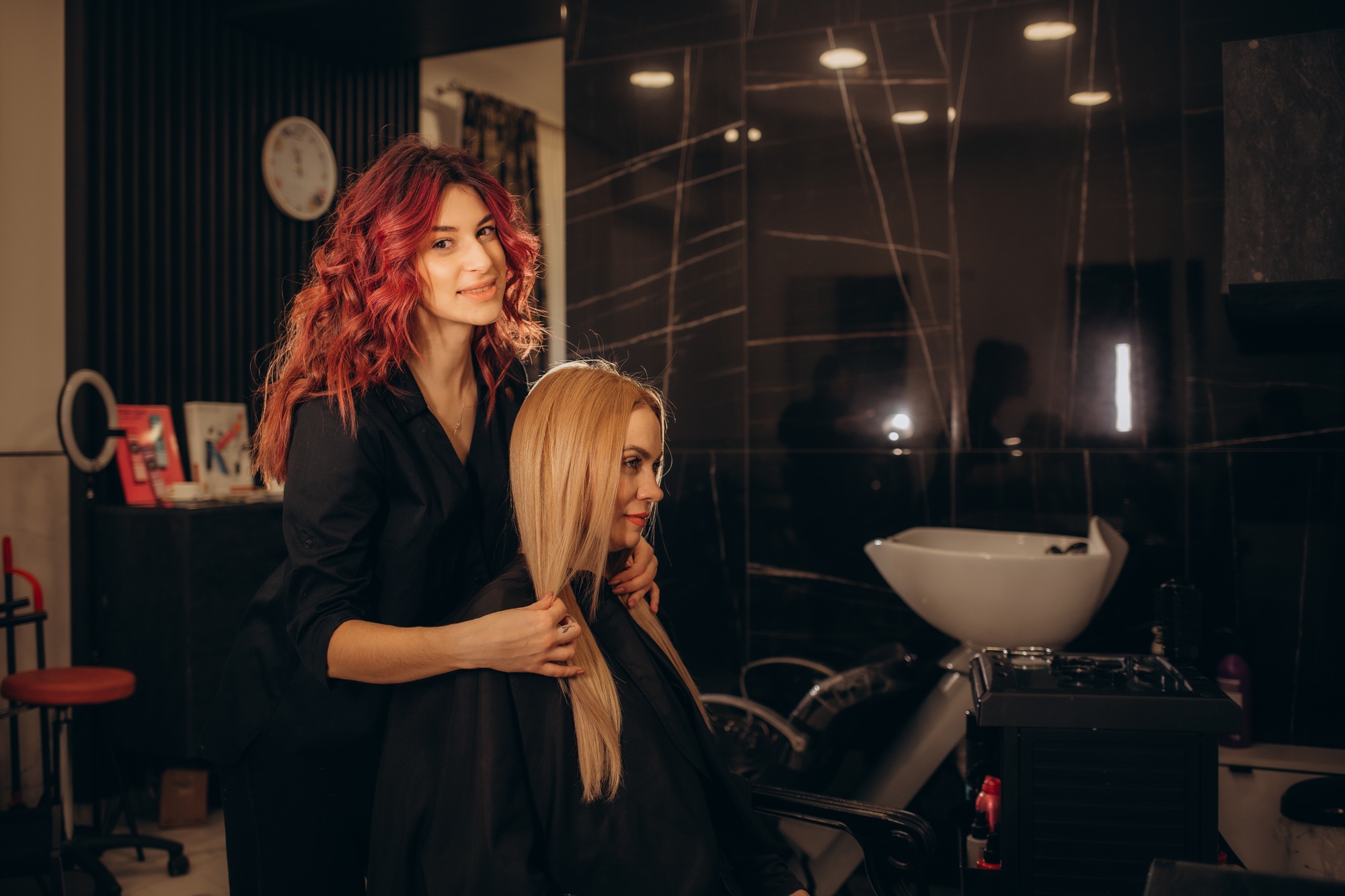 Hairstylist trimming hair of the customer in a beauty salon